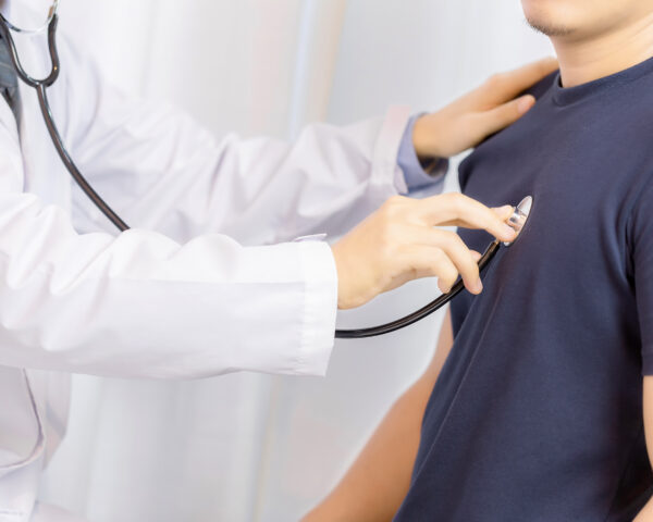 Doctor examination young man with stethoscope in hospital. healt Doctor examination young man with stethoscope in hospital. healthcare and medicine